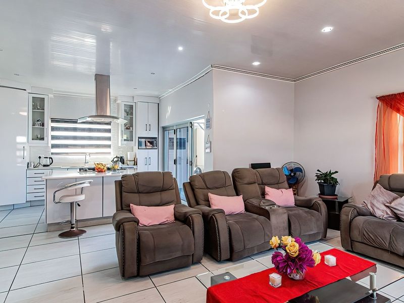 Spacious open-plan living area featuring a modern kitchen with built-in cabinetry, a central island, and seamless flow to the lounge space.
