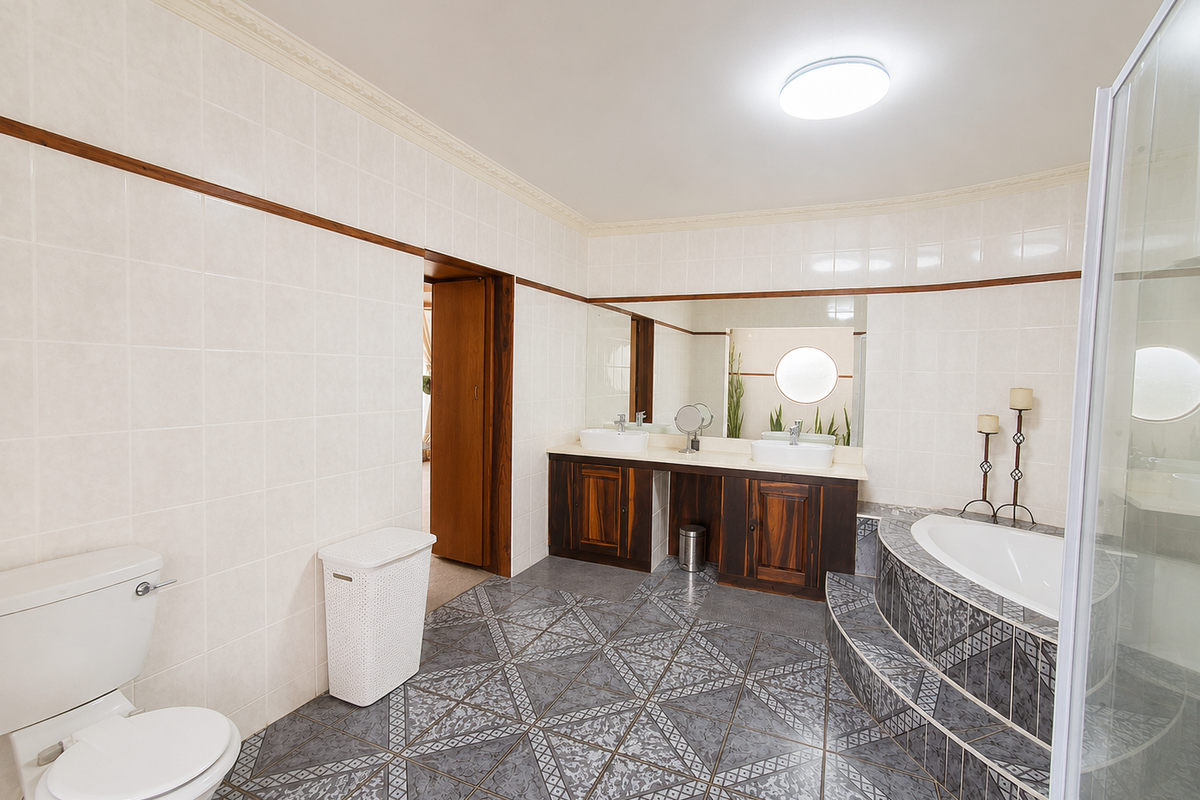 Spacious bathroom featuring a double vanity with vessel sinks, a raised platform bathtub, a separate shower enclosure, and decorative ceramic floor tiling.