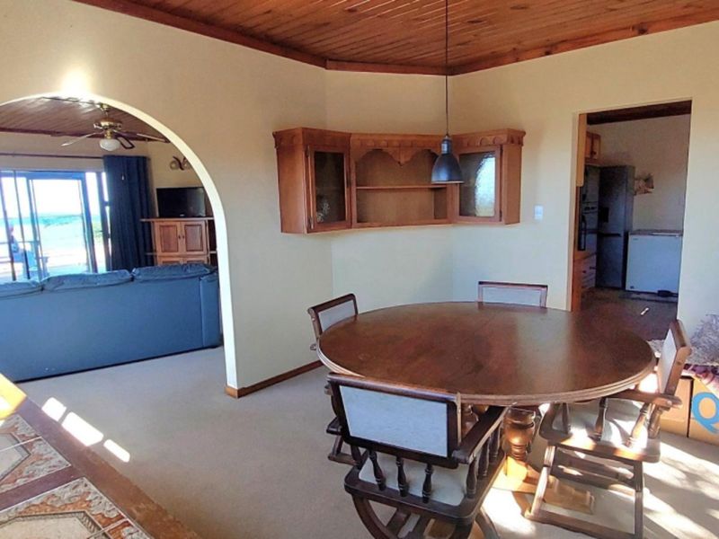 Open plan dining area featuring a timber ceiling, arched transition to the living space, and built-in wall cabinetry.