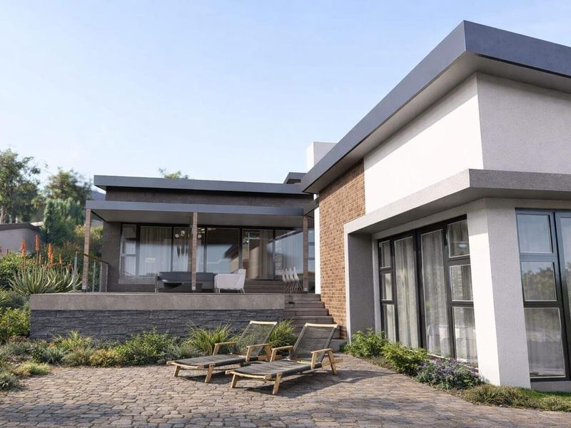 A modern rear exterior view featuring a paved patio, raised deck area, stone cladding, and large aluminium sliding doors leading into the home.