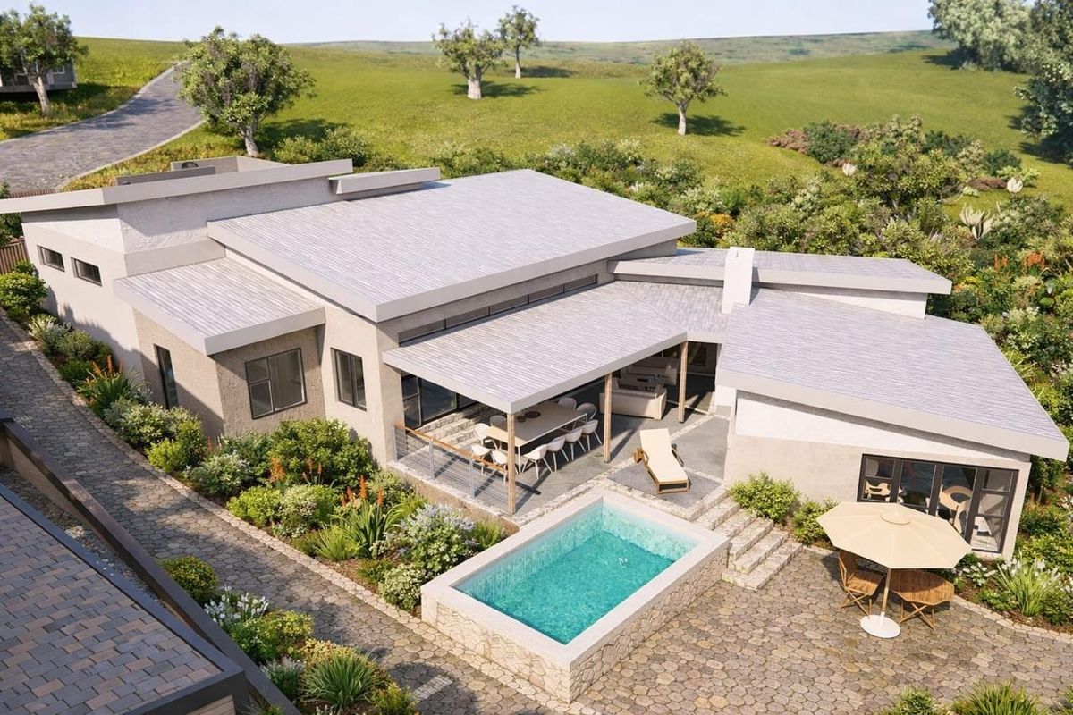 Aerial view of a modern residential property featuring a swimming pool, covered patio, and landscaped garden set within a scenic landscape.