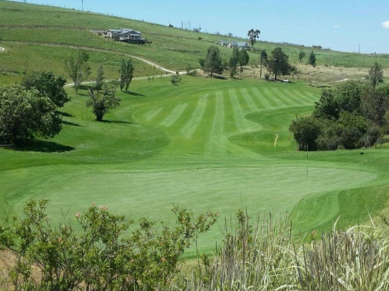 A scenic view overlooking a well-maintained golf course set within a rolling landscape.