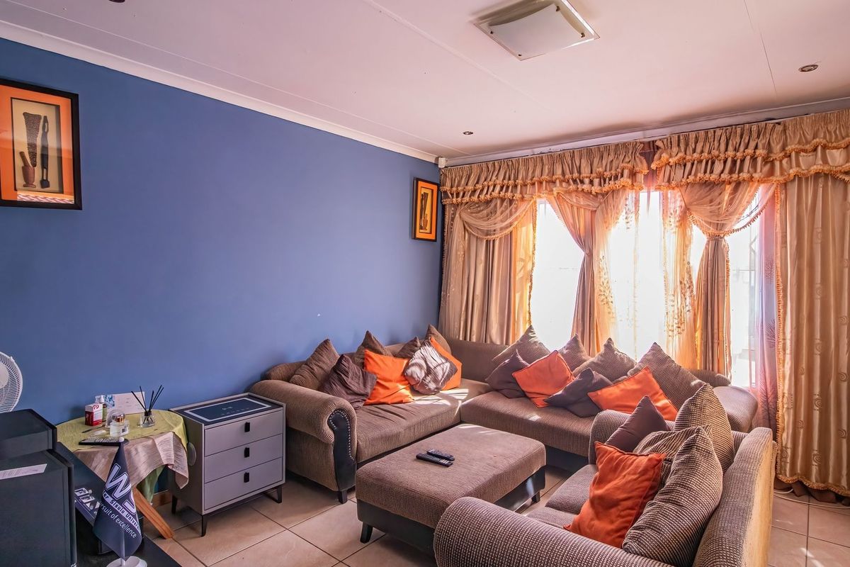 A living room featuring tiled flooring and recessed ceiling lighting, providing a functional space for relaxation.