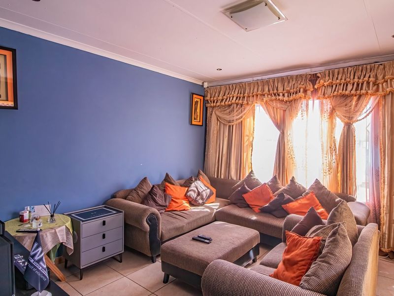 A living room featuring tiled flooring and recessed ceiling lighting, providing a functional space for relaxation.