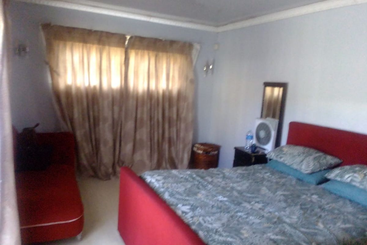A standard bedroom featuring neutral wall finishes, coving, and a window with curtains.