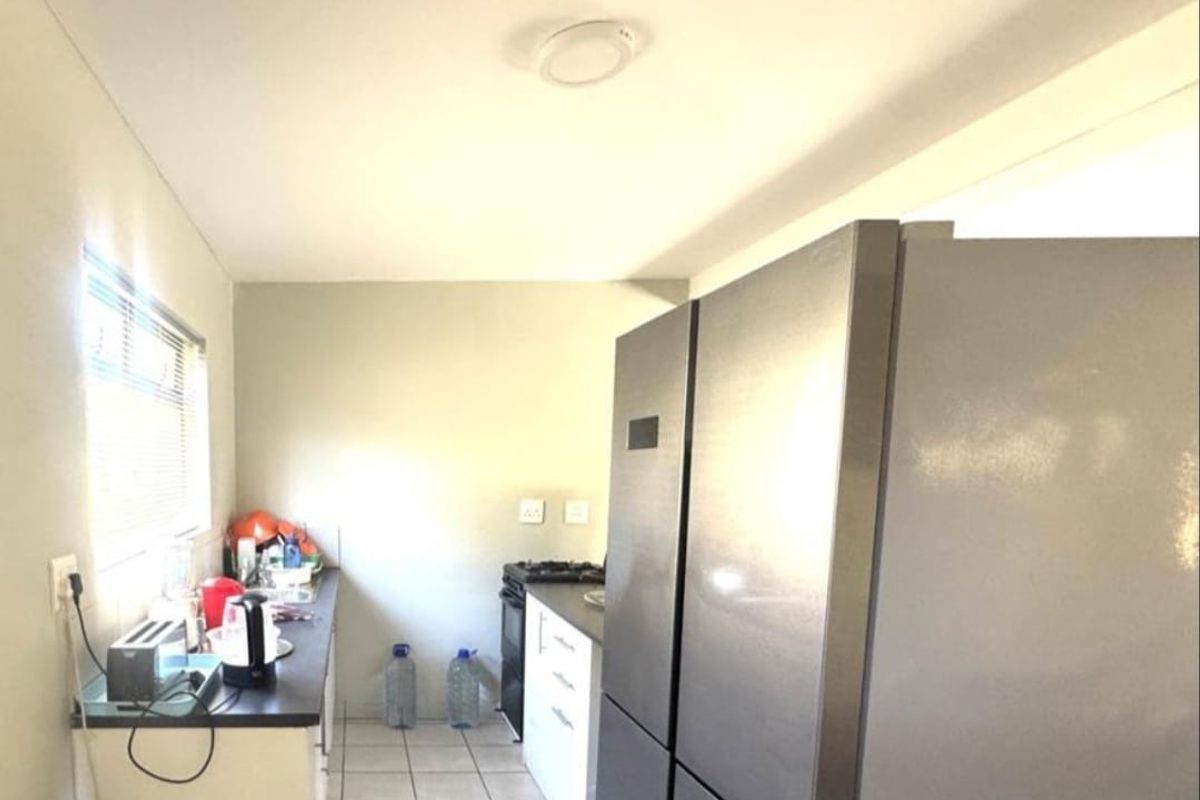 A functional kitchen area featuring tiled flooring, laminate countertops, built-in cabinetry, and a gas stove, providing a practical workspace for daily cooking.