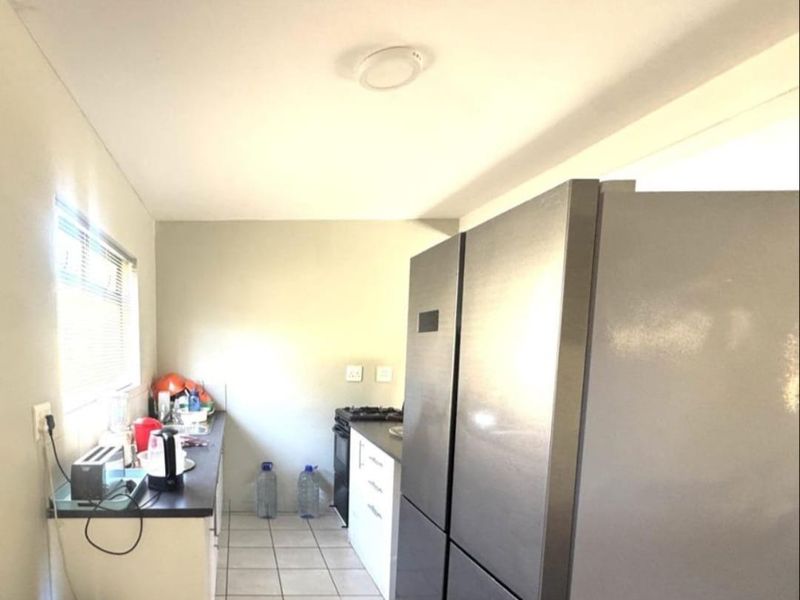 A functional kitchen area featuring tiled flooring, laminate countertops, built-in cabinetry, and a gas stove, providing a practical workspace for daily cooking.