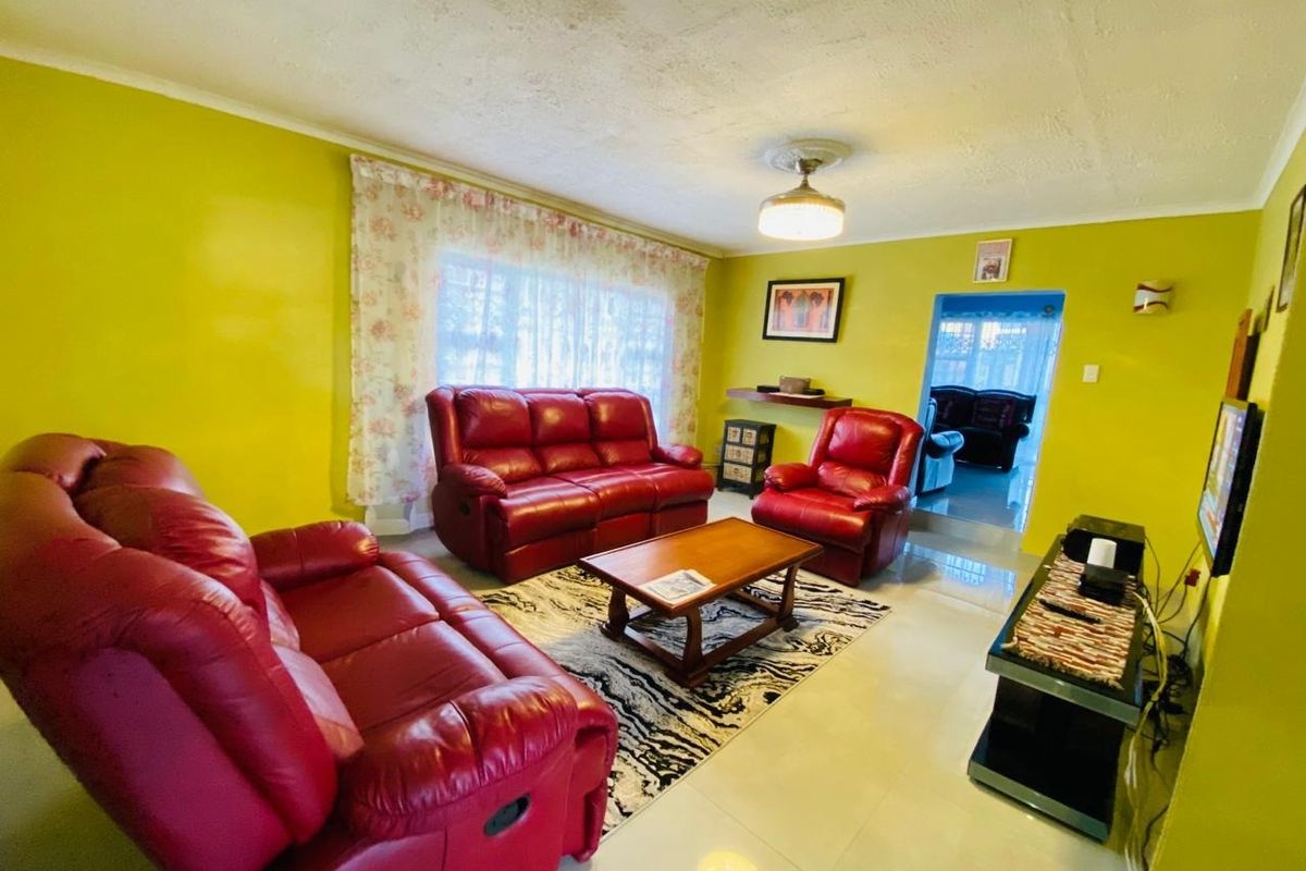 A living room featuring tiled flooring and a central ceiling light fixture, with visible signs of wear on the ceiling surface.