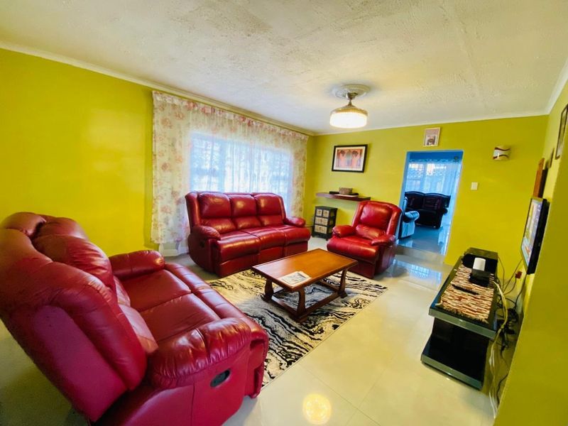 A living room featuring tiled flooring and a central ceiling light fixture, with visible signs of wear on the ceiling surface.