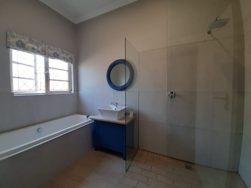 Modern bathroom featuring a built-in bathtub, a separate walk-in shower with a glass screen, and a vanity unit with a vessel sink.