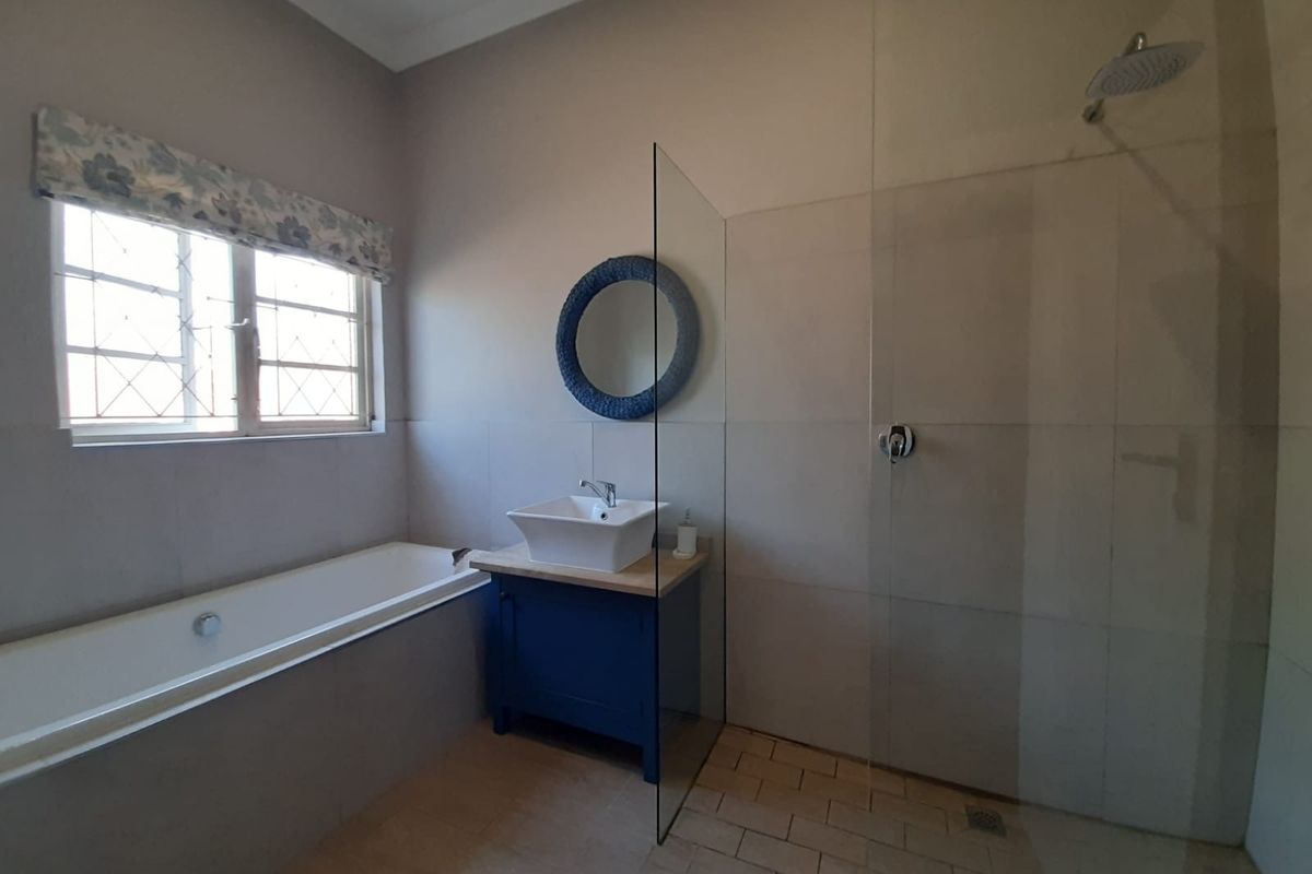 Modern bathroom featuring a built-in bathtub, a separate walk-in shower with a glass screen, and a vanity unit with a vessel sink.