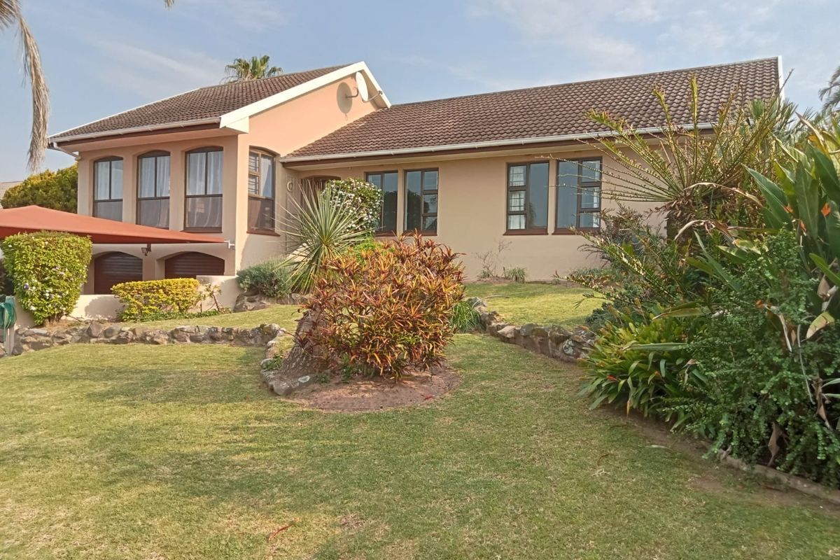 A well-maintained single-story residential home featuring a tiled roof, aluminium window frames, and a landscaped garden with stone edging.