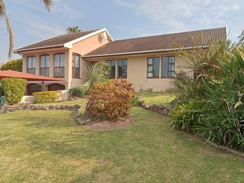 A well-maintained single-story residential home featuring a tiled roof, aluminium window frames, and a landscaped garden with stone edging.