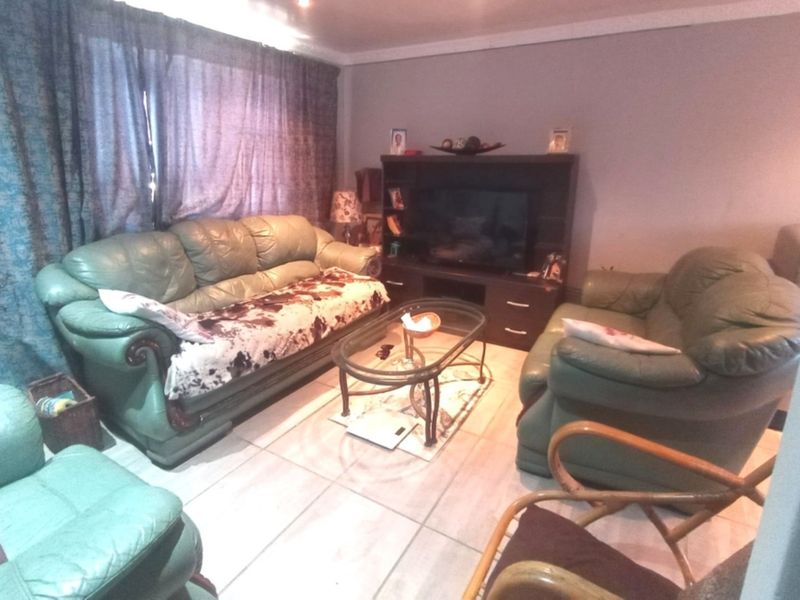 A living room featuring tiled flooring and coved ceiling details, providing a functional space for relaxation.