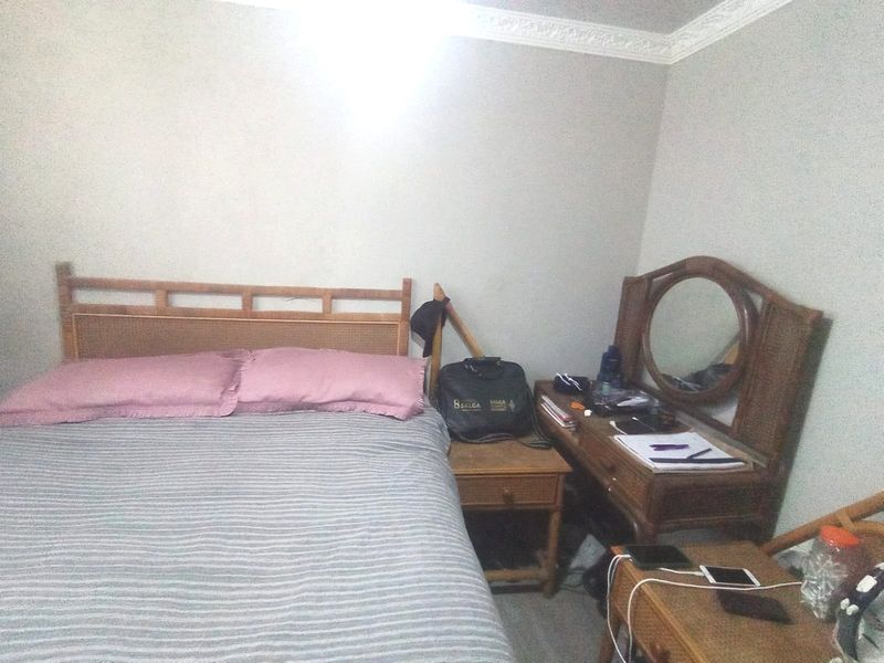 A standard bedroom featuring neutral wall finishes and decorative ceiling cornicing.