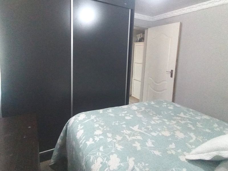 A bedroom featuring a large built-in wardrobe with sliding doors and decorative crown molding.