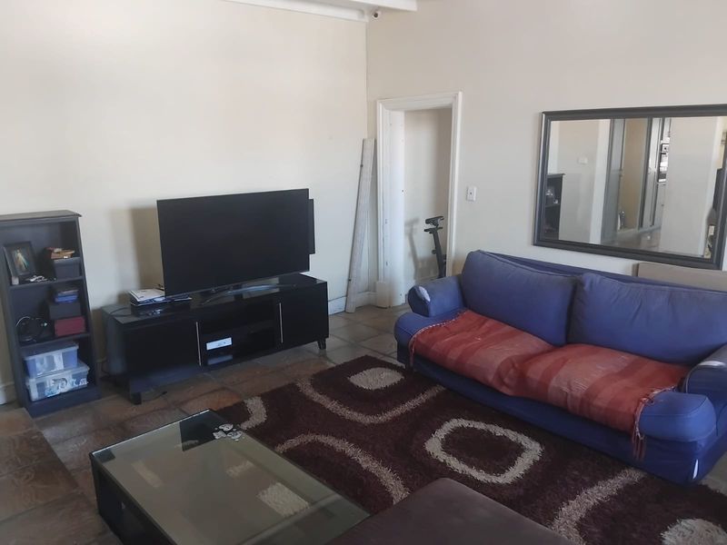 A living room featuring tiled flooring and neutral wall finishes, providing a functional space for relaxation.