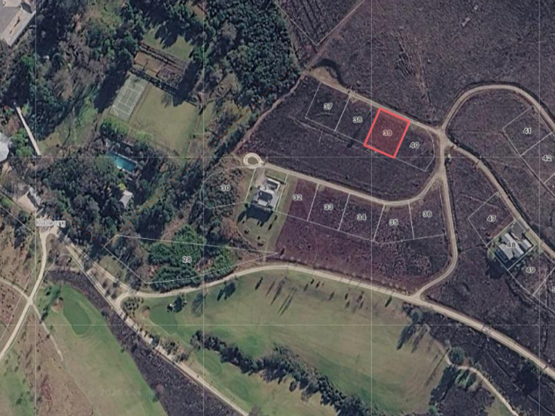 Aerial view of a vacant residential land plot, identified as lot 39, situated within a developed estate with established road access.