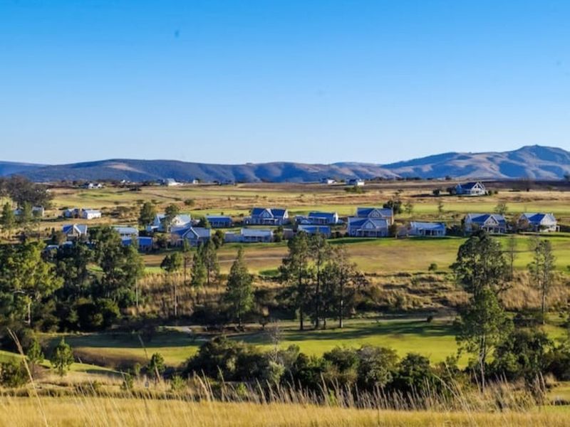 A scenic elevated view of the surrounding landscape, rolling hills, and distant mountain range, showcasing the natural beauty of the estate.
