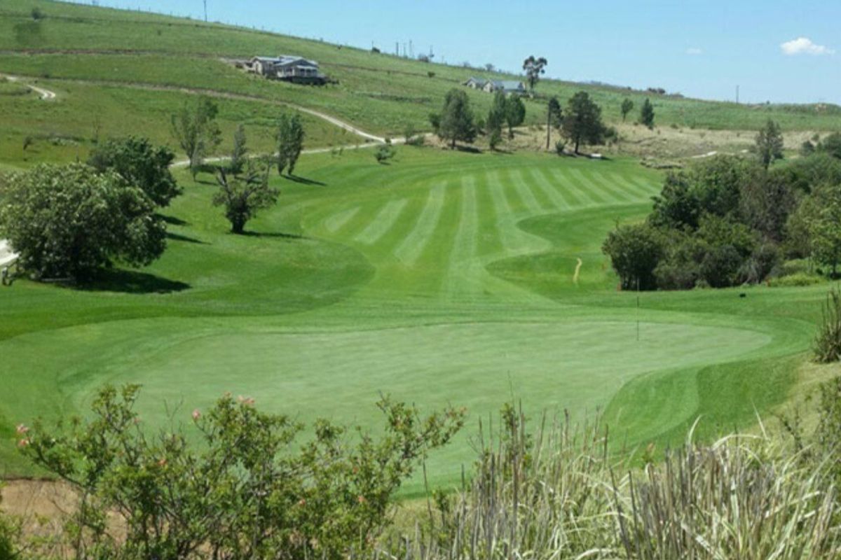 A scenic view overlooking a well-maintained golf course set within a rolling landscape.