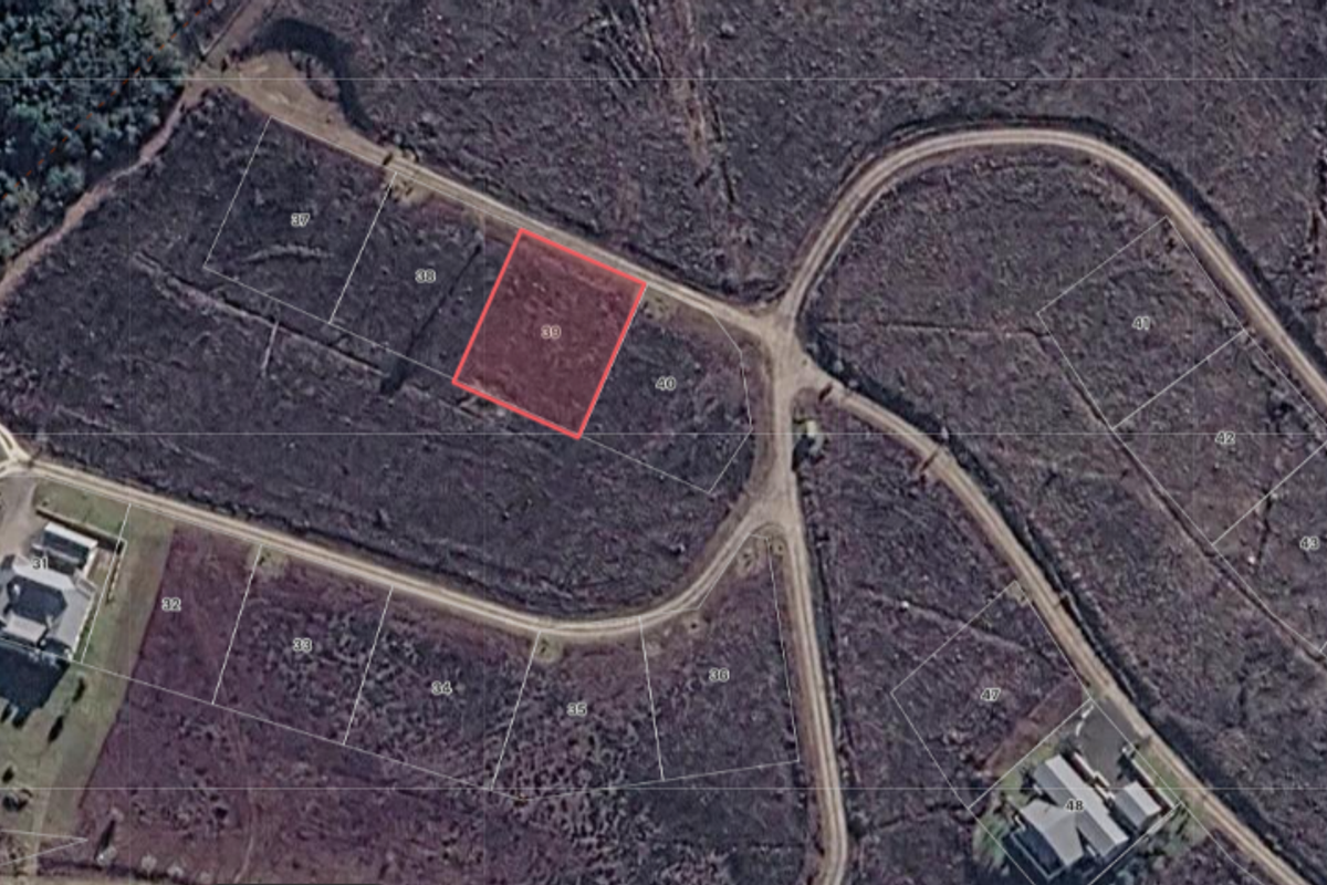 Aerial view of a vacant residential land plot, identified as lot 39, situated within a developing estate with established road access.