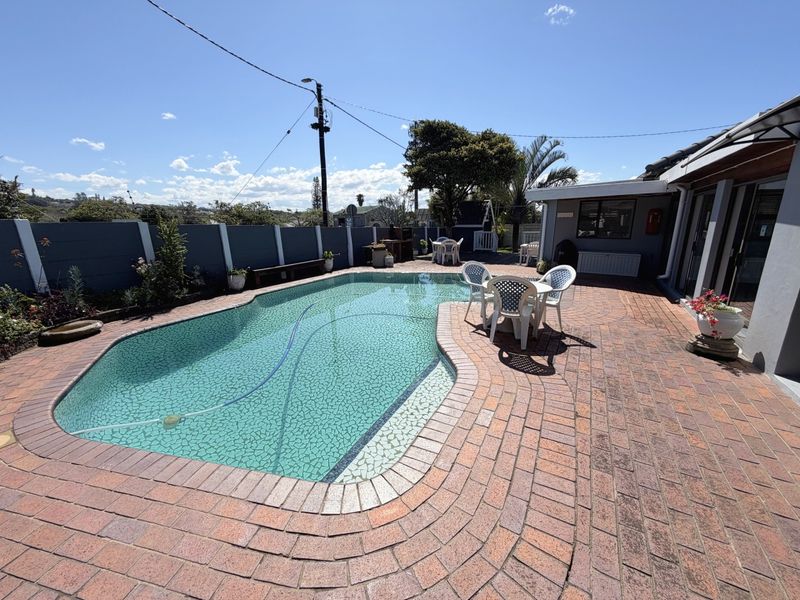 Outdoor pool area featuring a swimming pool, brick paved patio, and boundary wall, providing a functional space for outdoor relaxation and entertainment.