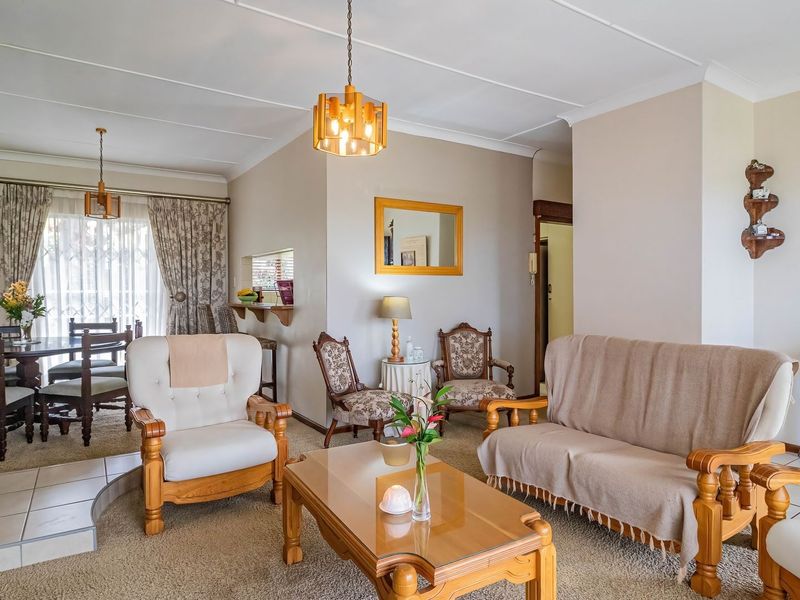 Spacious open-plan living and dining area featuring a freestanding fireplace with a tiled hearth and neutral wall finishes.
