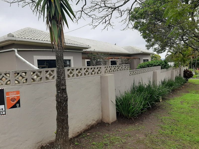 Front exterior view of the property featuring a concrete boundary wall with decorative breeze blocks and a tiled roof.