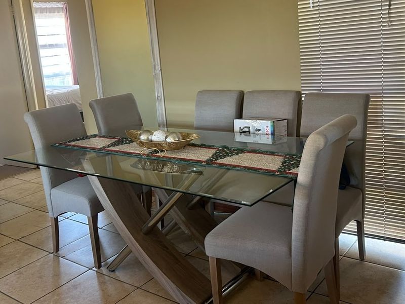 A dining area featuring tiled flooring and venetian blinds, providing a functional space for meals.
