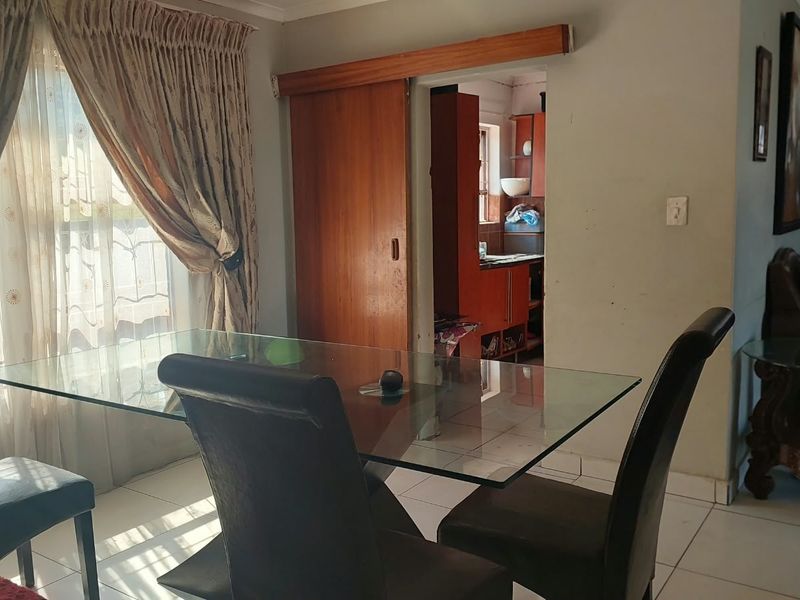 Dining area featuring tiled flooring and a sliding door providing access to the adjacent kitchen space.