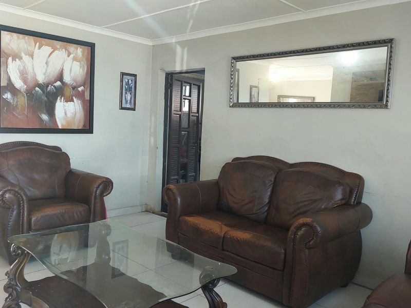 A living room featuring tiled flooring and a coved ceiling, providing a functional space for relaxation.