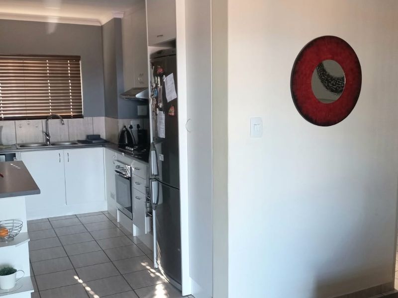 A functional kitchen featuring white cabinetry, stainless steel appliances, tiled flooring, and a convenient breakfast bar area.