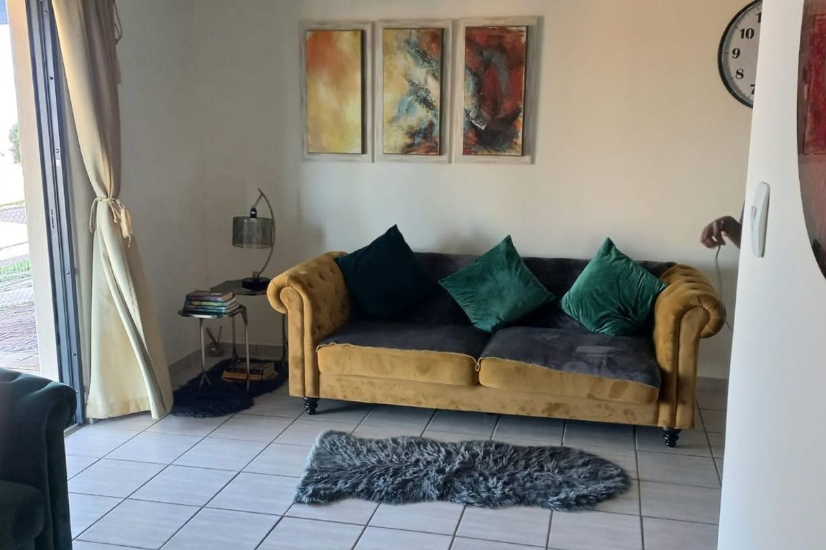 A living room area featuring tiled flooring and a sliding glass door providing access to the exterior.