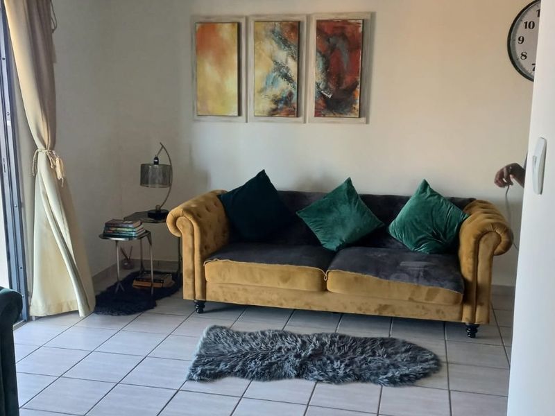 A living room area featuring tiled flooring and a sliding glass door providing access to the exterior.