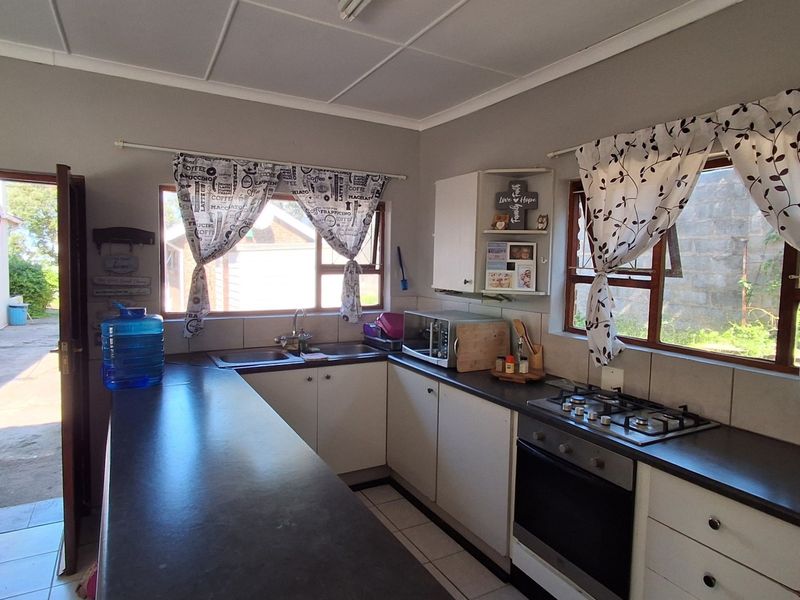 Functional kitchen featuring built-in cabinetry, laminate countertops, a gas hob, and an integrated oven, with direct access to the exterior.