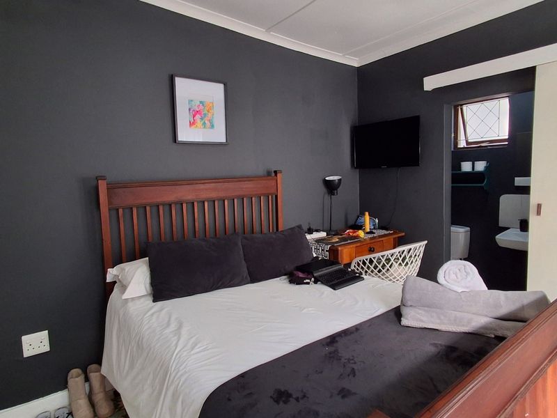 A bedroom featuring dark painted walls and an en-suite bathroom access point with a sliding door.