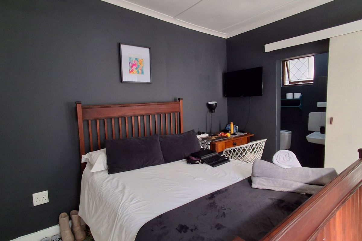 A bedroom featuring dark painted walls and an en-suite bathroom access point with a sliding door.