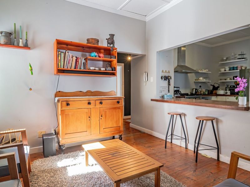Open plan living area featuring timber flooring and a breakfast bar pass-through connecting to the kitchen.