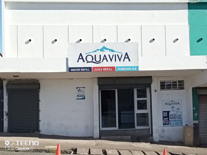 Front facade of a retail premises featuring roller shutter doors, glass entrance, and prominent business signage.