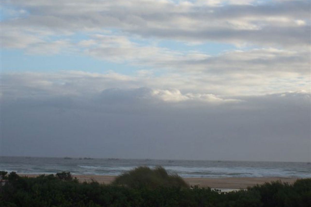 A scenic view of the ocean and coastline, showcasing the natural landscape and horizon.