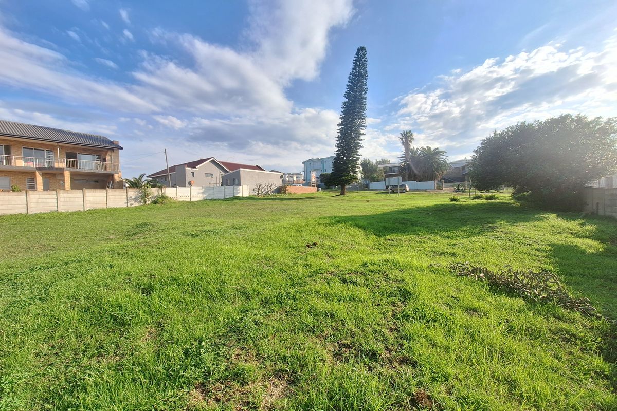 A spacious, level residential vacant plot featuring established grass cover and perimeter boundary walls in a developed neighborhood setting.