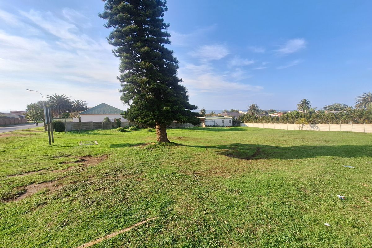 A spacious, level residential plot featuring a large mature tree and enclosed by perimeter walling, offering potential for future development.