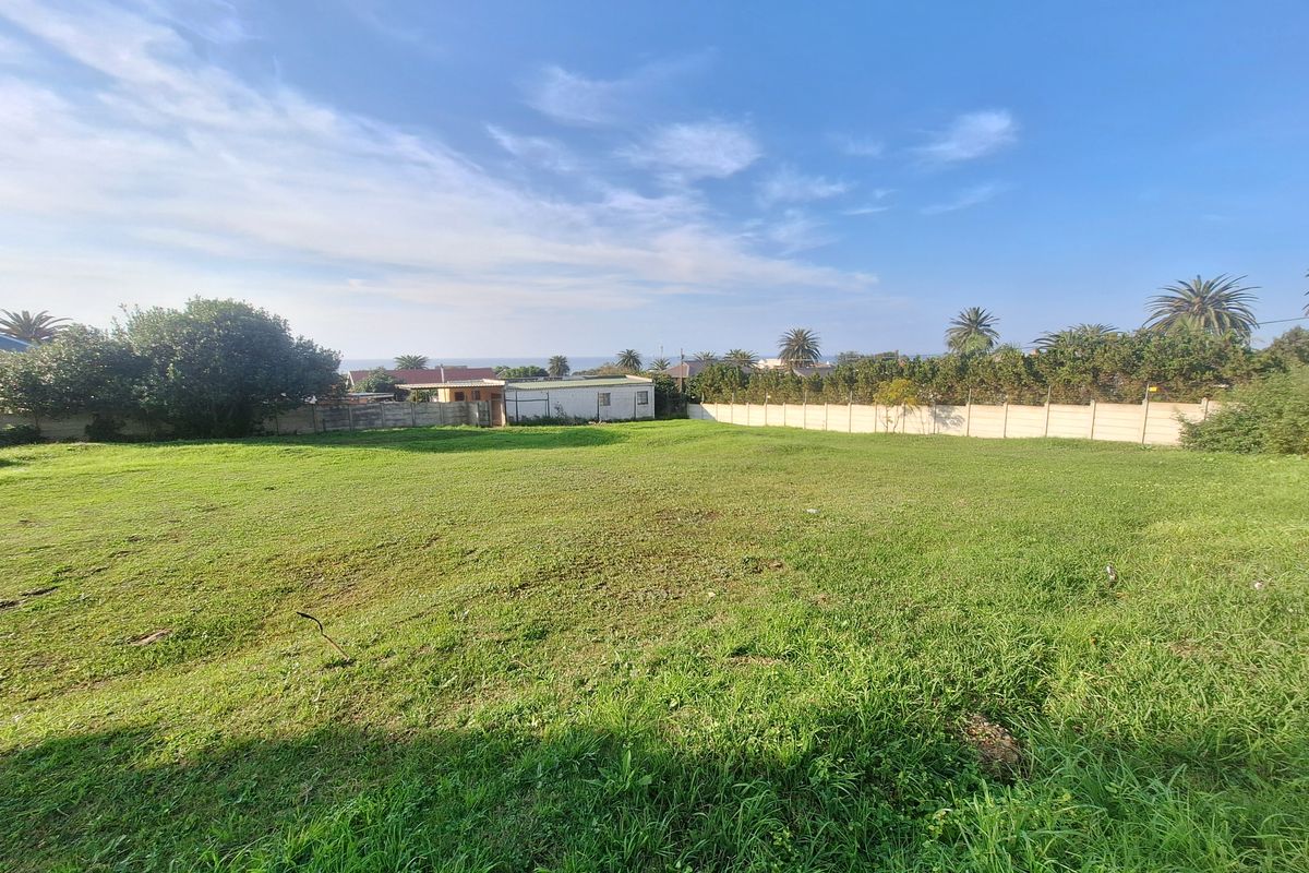 A spacious, level residential plot featuring a well-maintained grass lawn and secure precast concrete boundary walls.