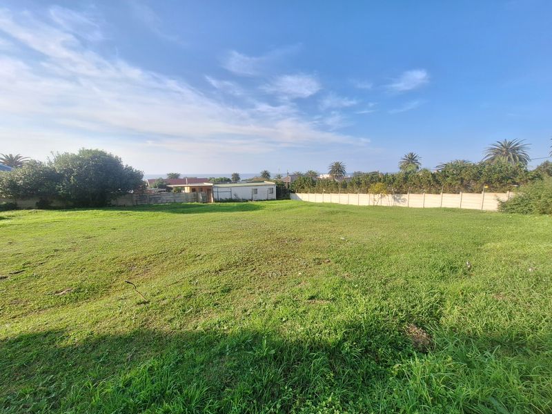 A spacious, level residential plot featuring a well-maintained grass lawn and secure precast concrete boundary walls.
