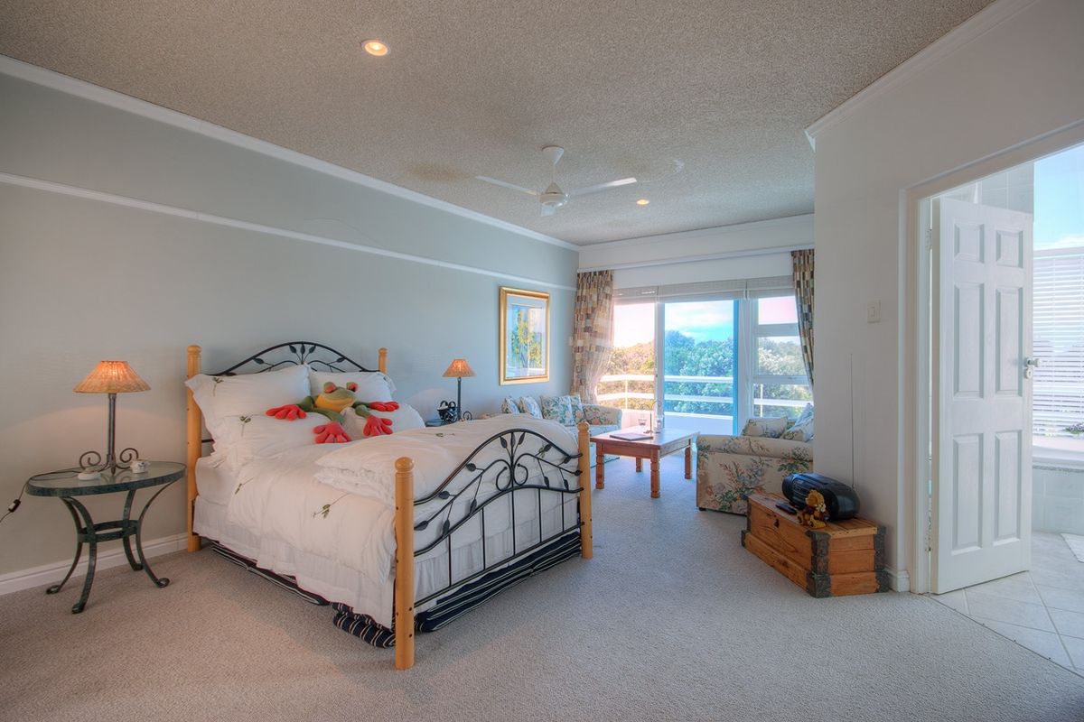 Spacious bedroom featuring neutral carpeting, a textured ceiling with recessed lighting, a ceiling fan, and sliding glass doors leading to an outdoor balcony.