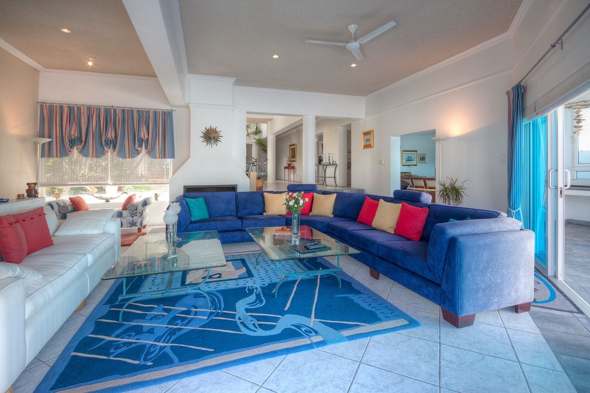 Spacious living room featuring tiled flooring, a central fireplace, ceiling fan, and large sliding glass doors providing access to the outdoor area.