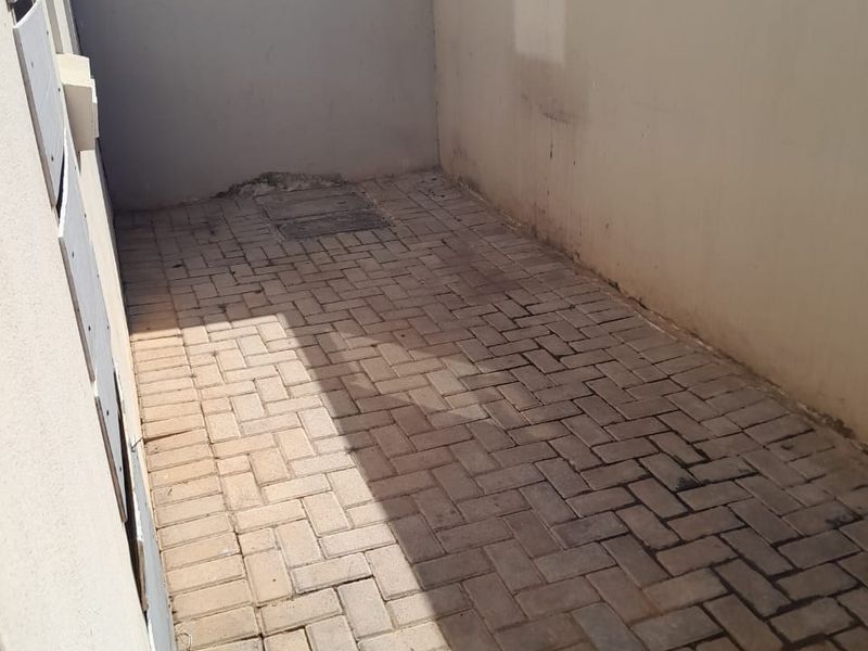 A private paved rear courtyard area enclosed by boundary walls, offering a functional outdoor space with potential for landscaping or patio development.