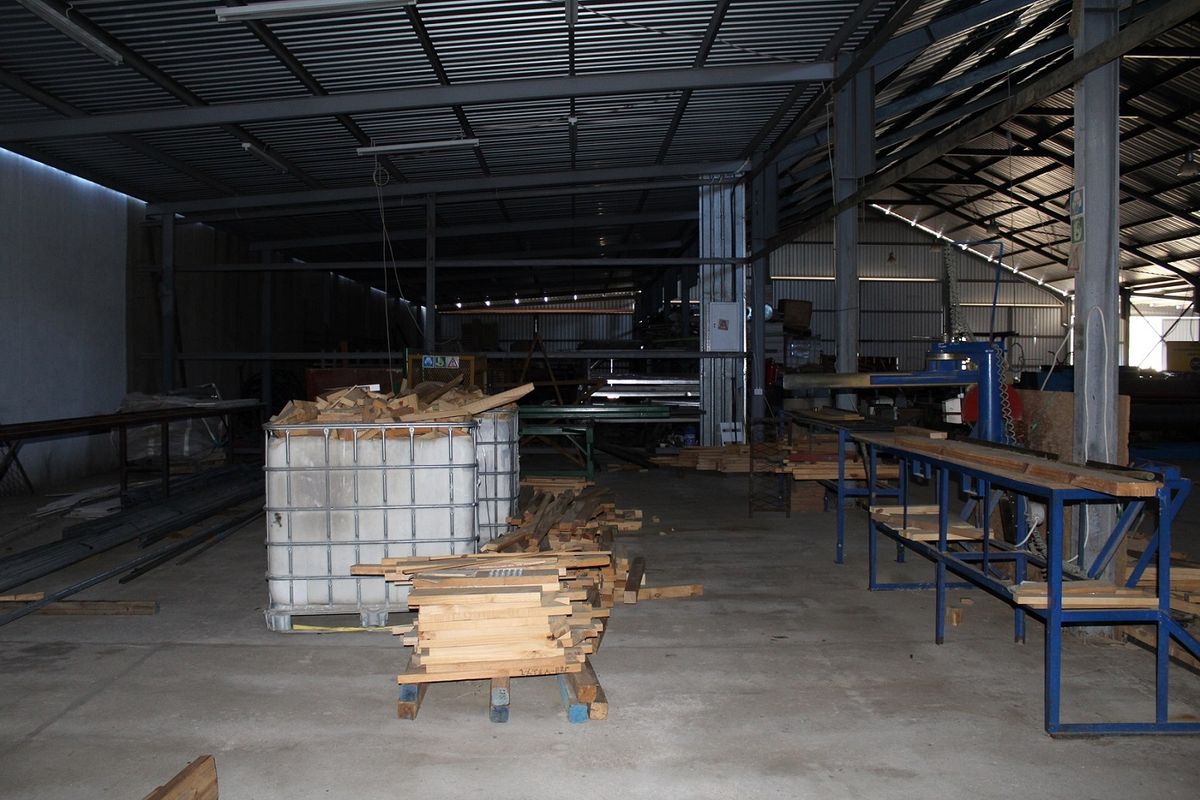 Spacious industrial warehouse area featuring high-clearance steel roof structure, concrete flooring, and open-plan layout suitable for manufacturing or storage operations.