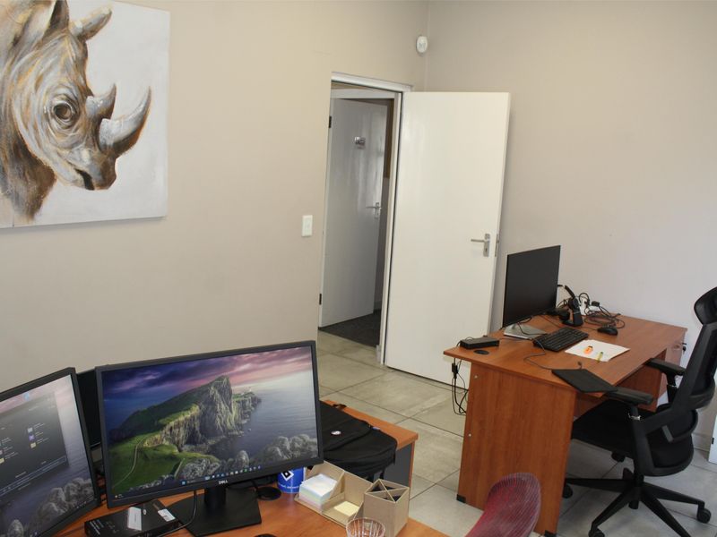 A functional office space featuring tiled flooring and neutral wall finishes, providing a practical work environment.