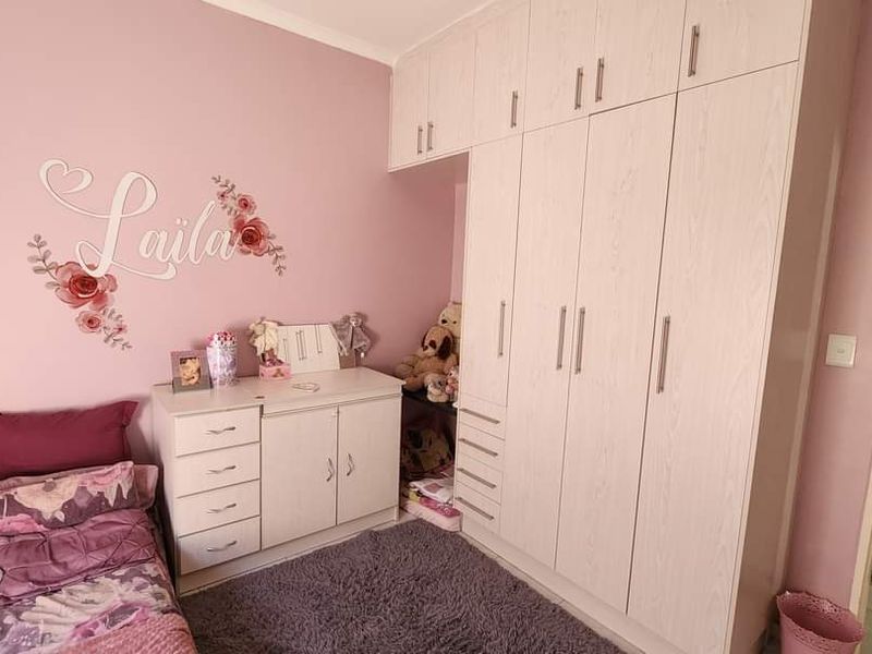 A bedroom featuring extensive built-in wardrobe storage and cabinetry, providing ample space for organization and storage.